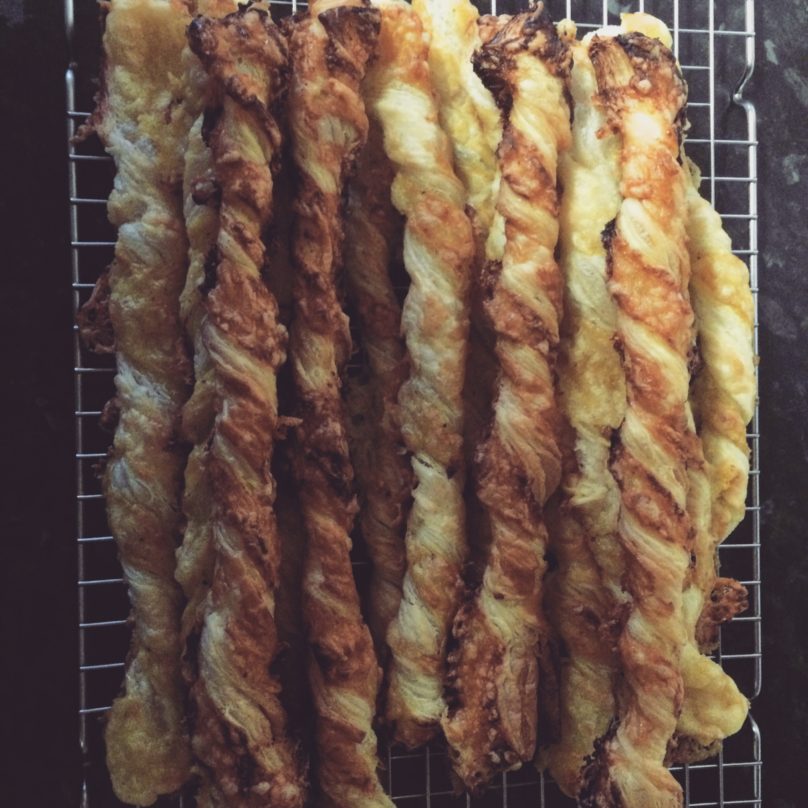 Cooked cheese straws on a cooling rack