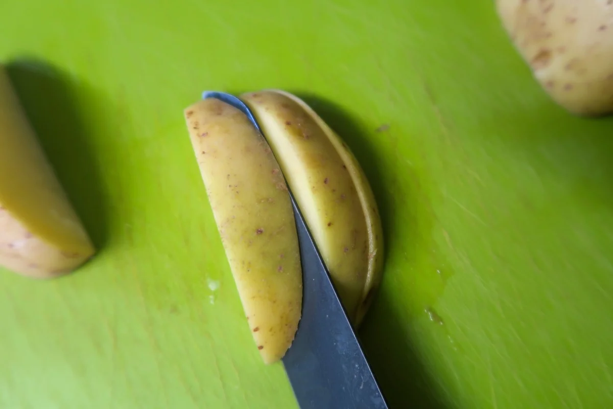 How to cut potato wedges - cutting potatoes into wedges from quarters.
