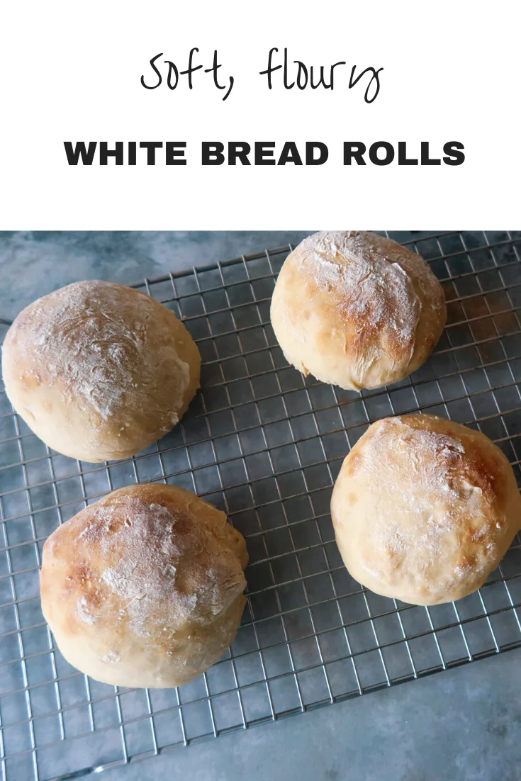 Soft white bread rolls on a cooling rack with text overlay that says Soft, floury white bread rolls