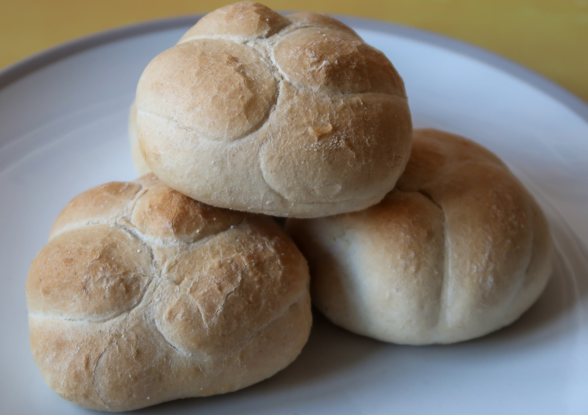 Bread rolls baked in the air fryer - three rolls on a plate with a pattern on the top of each one that resembles petals on a flower.