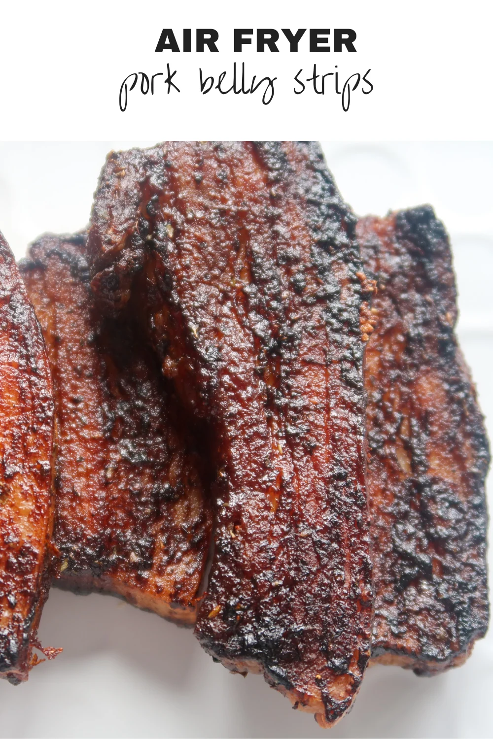 Crispy pork belly strips in a pile on a white platter