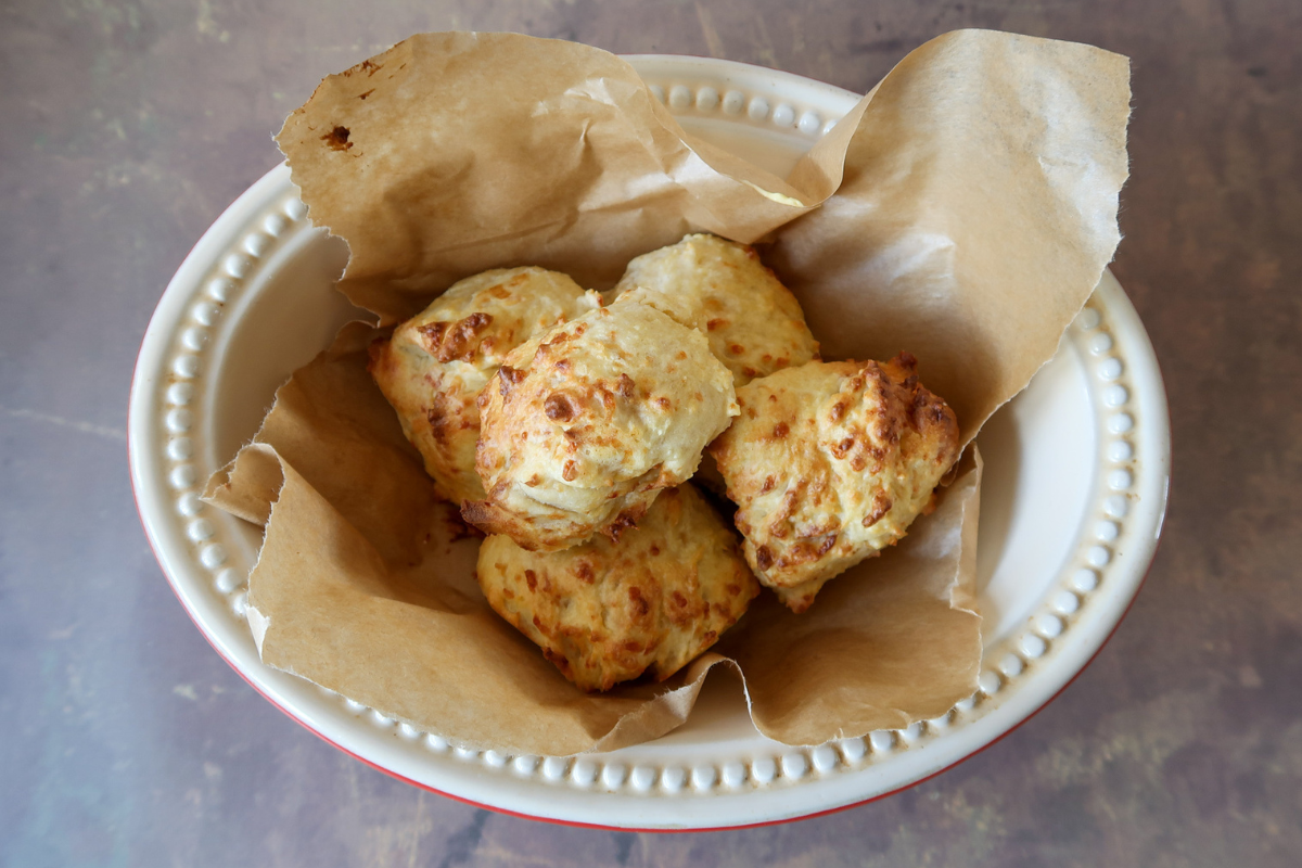 Crispy cheese scones cooked in the air fryer served on baking paper in a red Le Creuset pie dish
